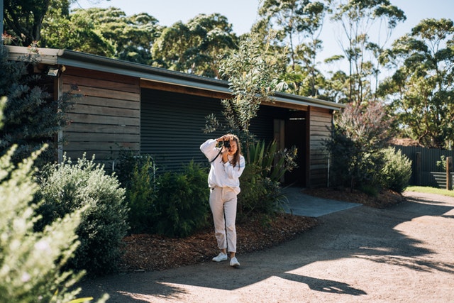 Žena, ktorá fotografuje pred malým, úzkym domom