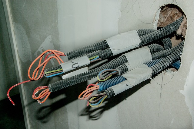 Elektrické káble v plastových chráničkách trčiace zo steny.jpg